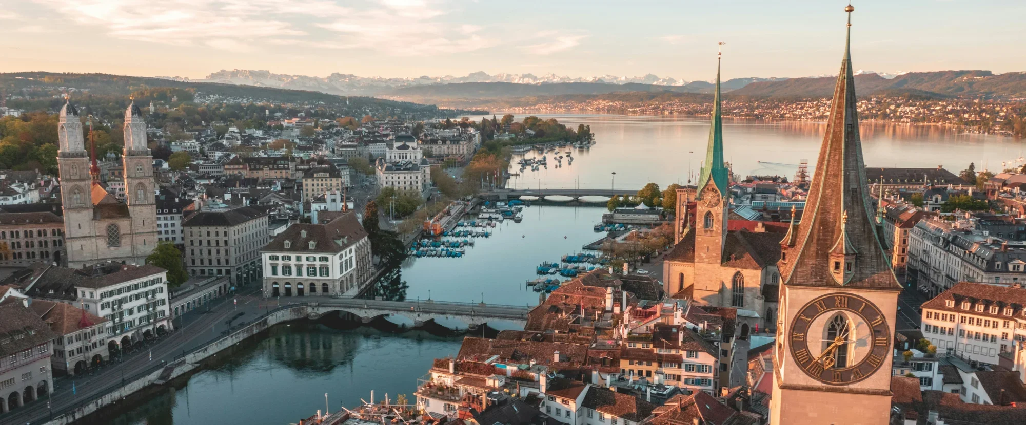 Aerial view of Zurich old town with three stone churches and river flowing into a lake