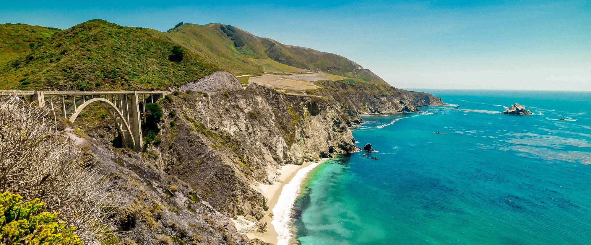 Arch of Bixby Bridge as it carries the Pacific Coast Highway beside the ocean in California