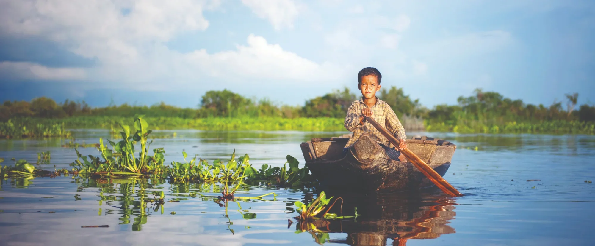 Local boy rowing in Tonle Sap, Cambodia
